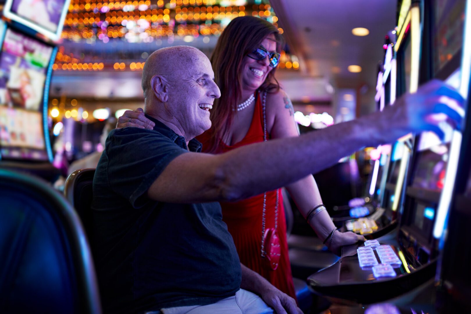 A man and woman playing video games in a casino.