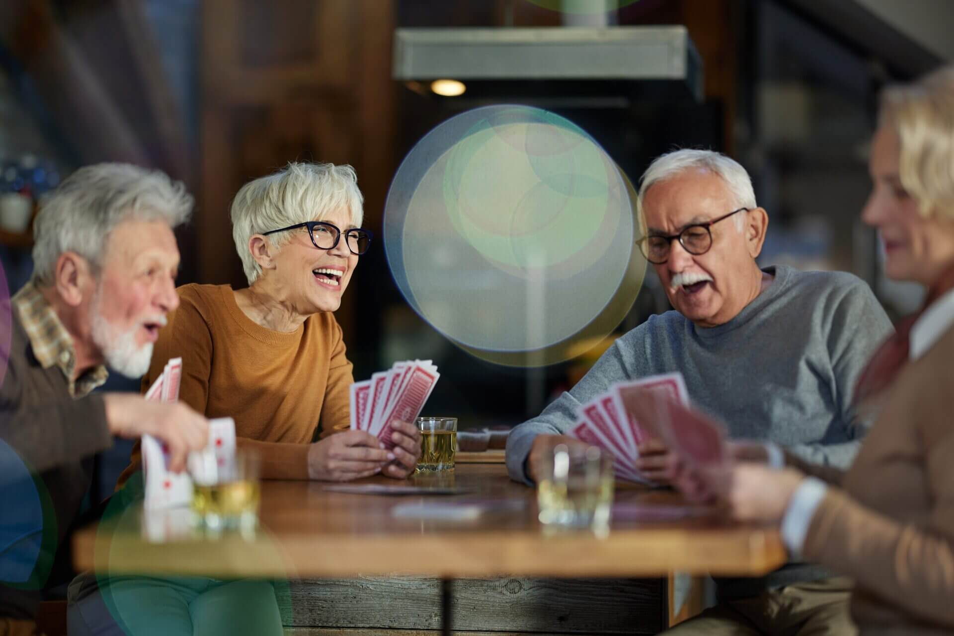 A group of people sitting at a table with cards.