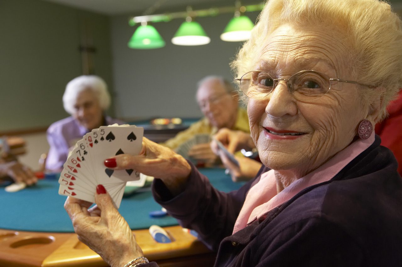 A woman holding up cards at a table.
