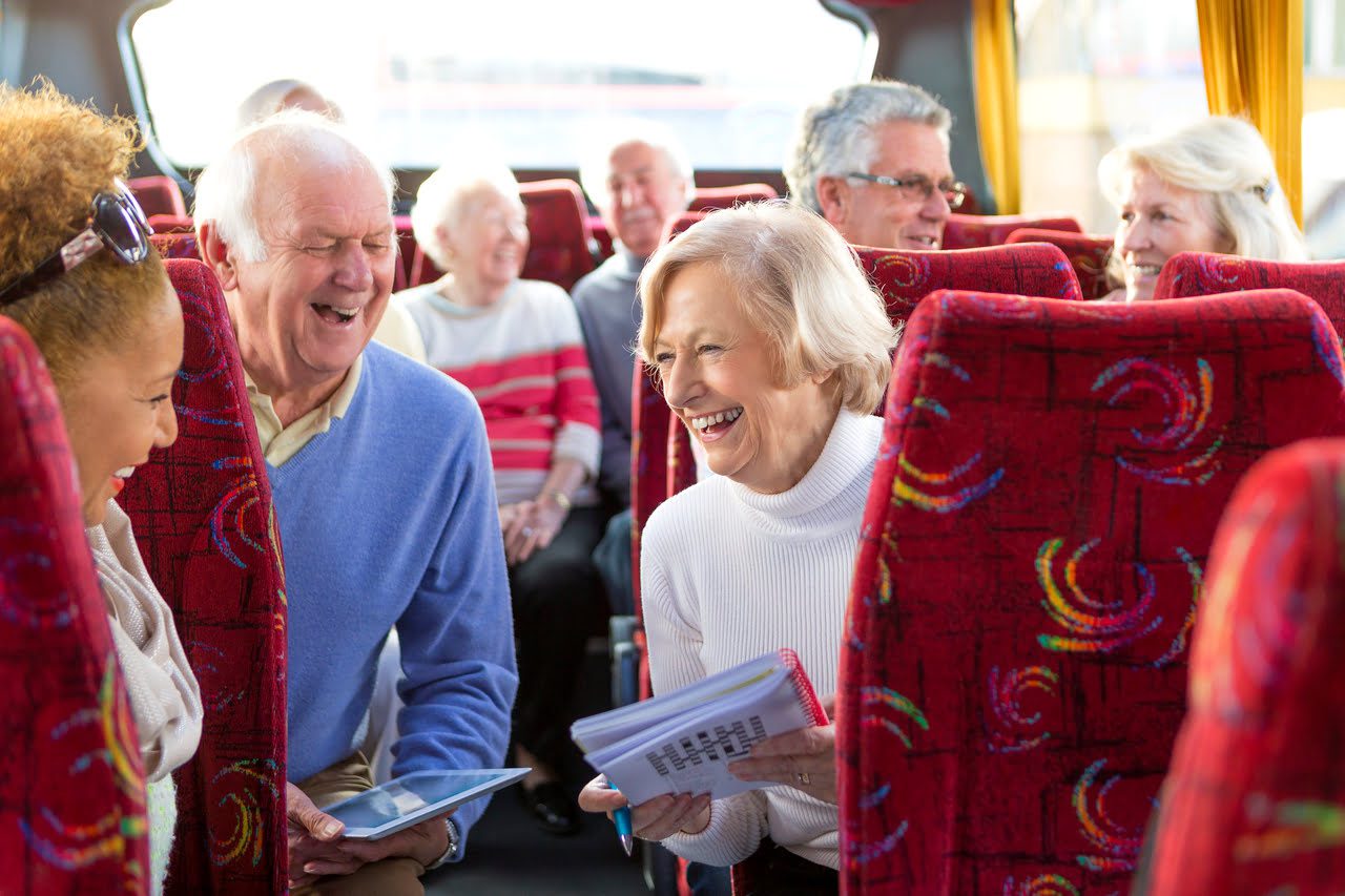 A group of people sitting on seats in a bus.