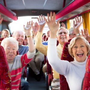 A group of people on a bus raising their hands.