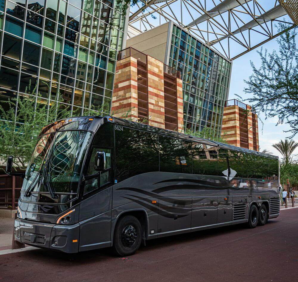 A black bus parked in front of a building.